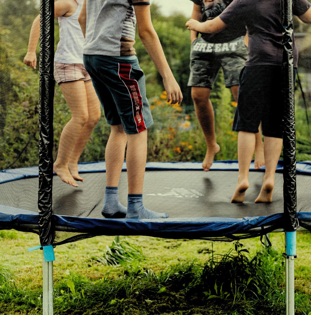 Kids jumping on a trampoline at dusk